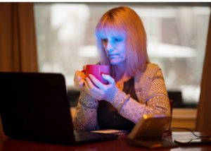 Woman working from home with a SAD lamp during the winter